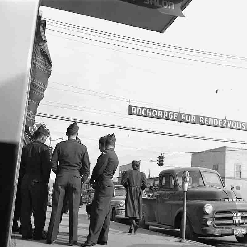 Soldiers in Anchorage, Alaska watch as a woman walks past them 