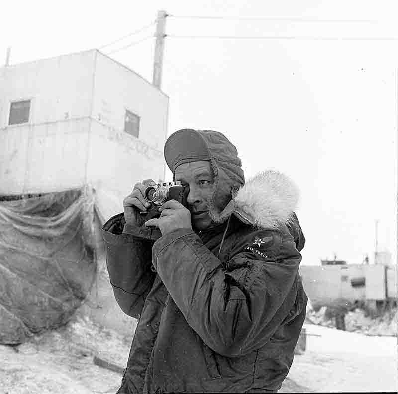 A man in a U.S. Air Force winter coat captures a photograph on Drifting Station Alpha in the Arctic Ocean.