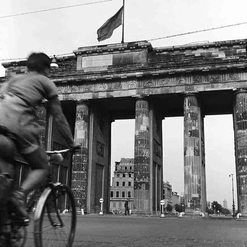 Cyclist riding through Brandenburg Gate in Berlin