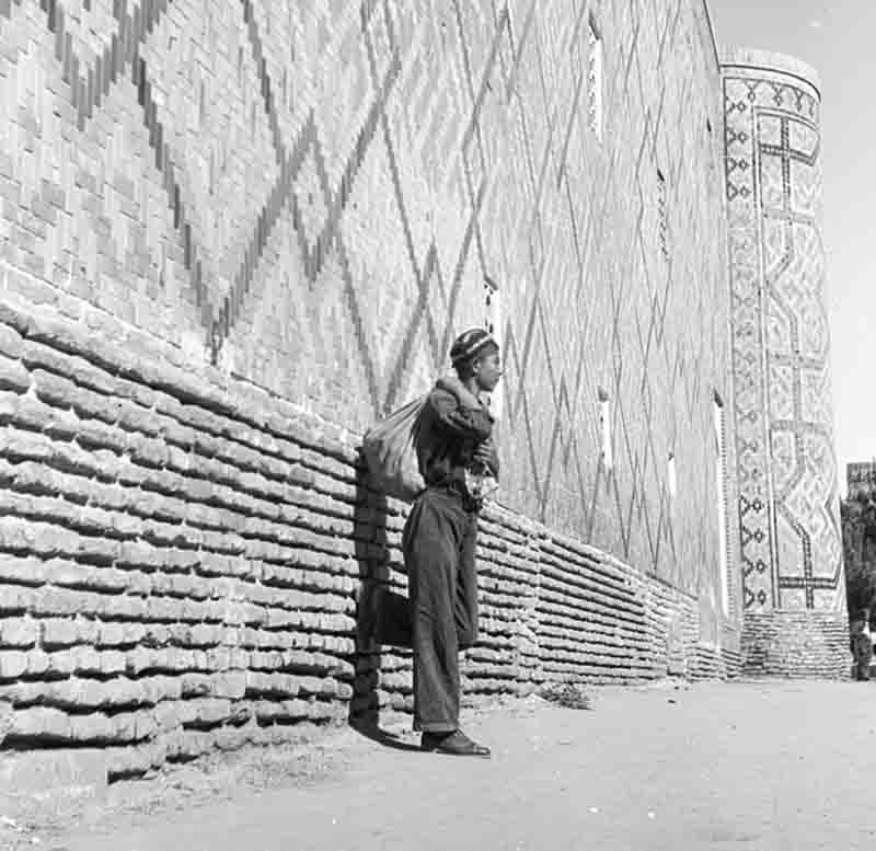 An Uzbek man stands at the castle wall in Bukhara 