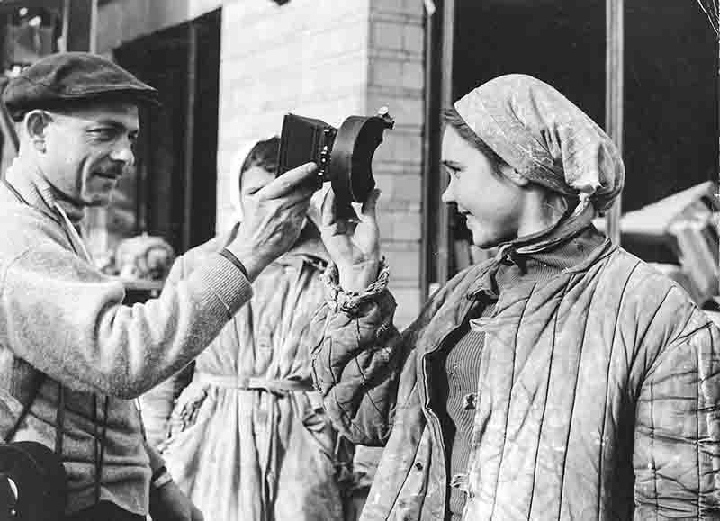 Woman examining a camera analog lens