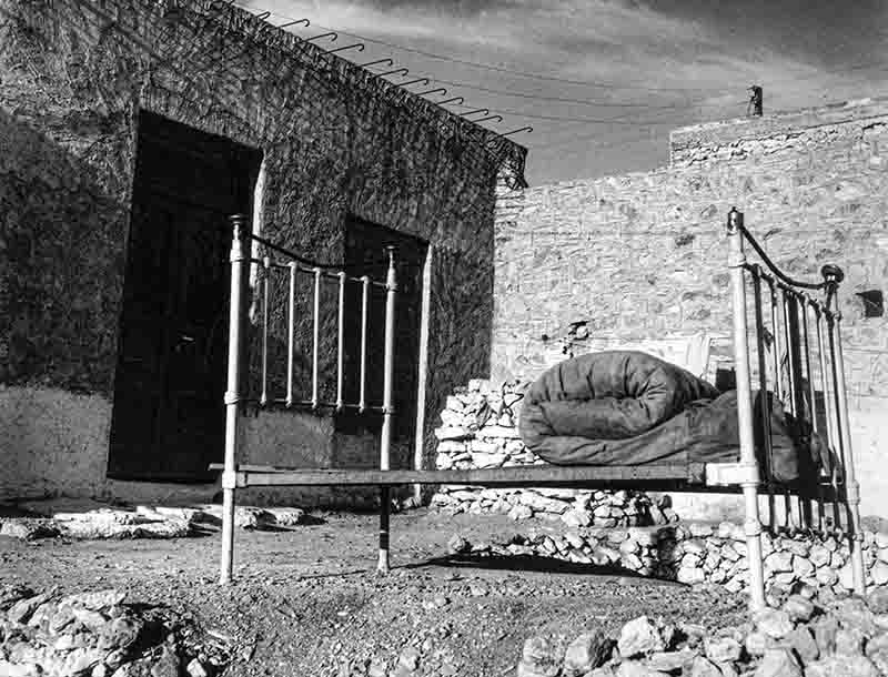 Field bed by a cottage of stones