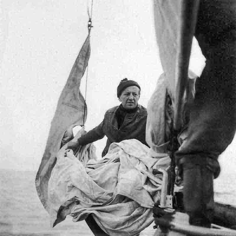 Fisherman raising sails on a boat in Volendam, Holland