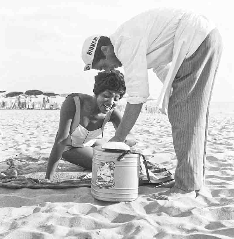 Woman and ice cream vendor on the beach in Italy