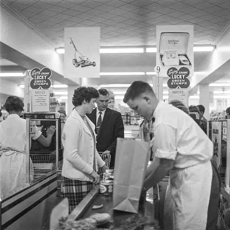 Cashiers and customers in a grocery store of the 50s in Alaska