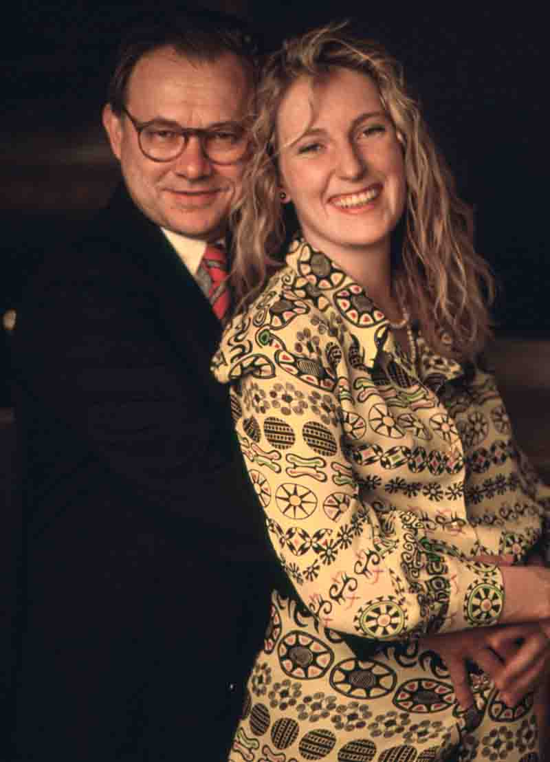 Wedding portrait of Hubert Burda wearing glasses and a suit standing behind a smiling Maria Furtwängler in a patterned jacket, photographed by Ingeborg Bock-Schroeder.