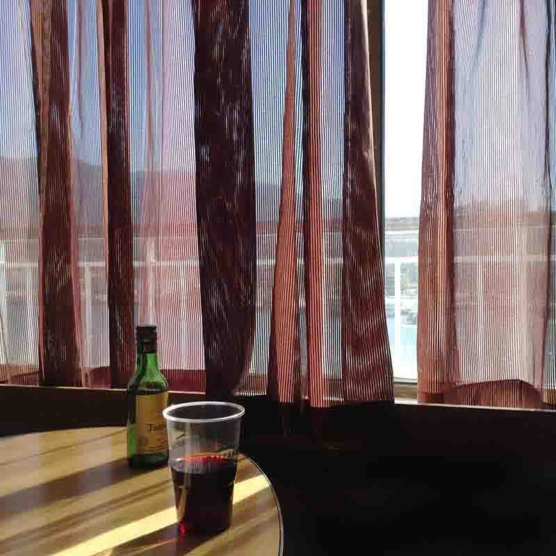 Bottle and glass of wine on a table on a ferry