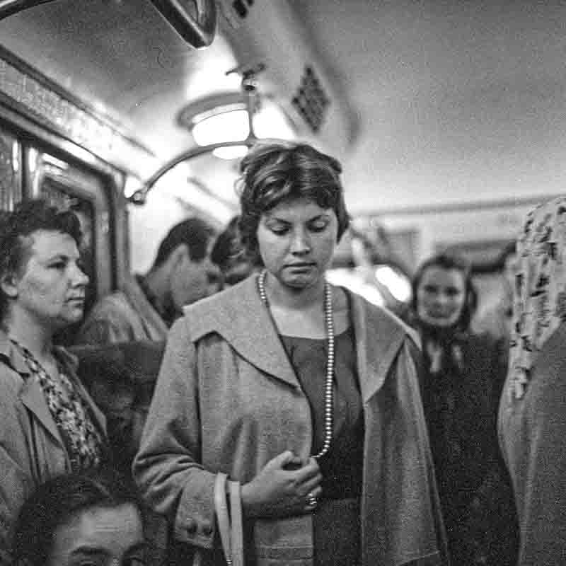 Young woman with pearl necklace in busy Moscow metro