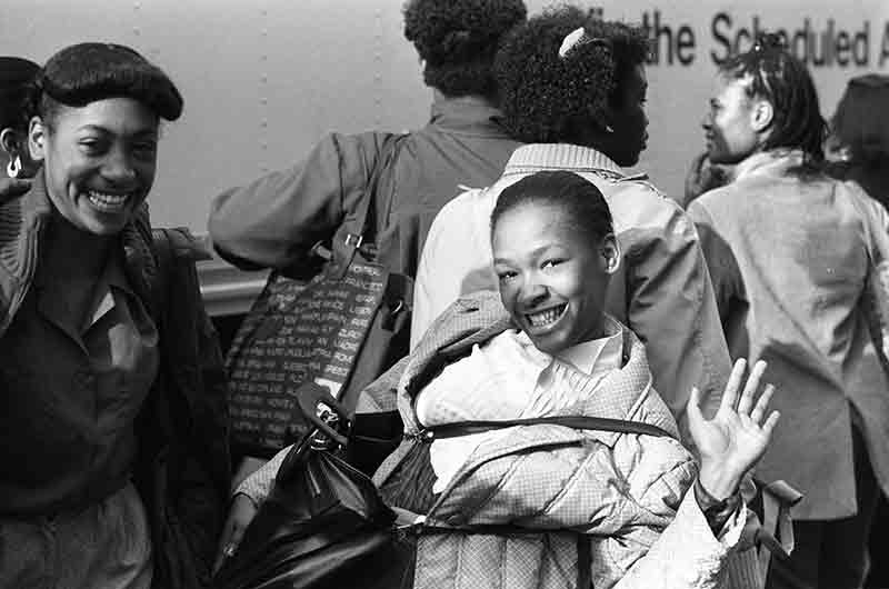 Black girl in New York waving at the photographer's camera