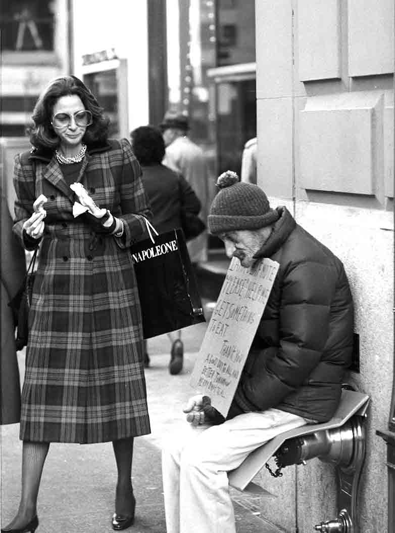 Rich woman in fur and beggar on the street in Manhattan