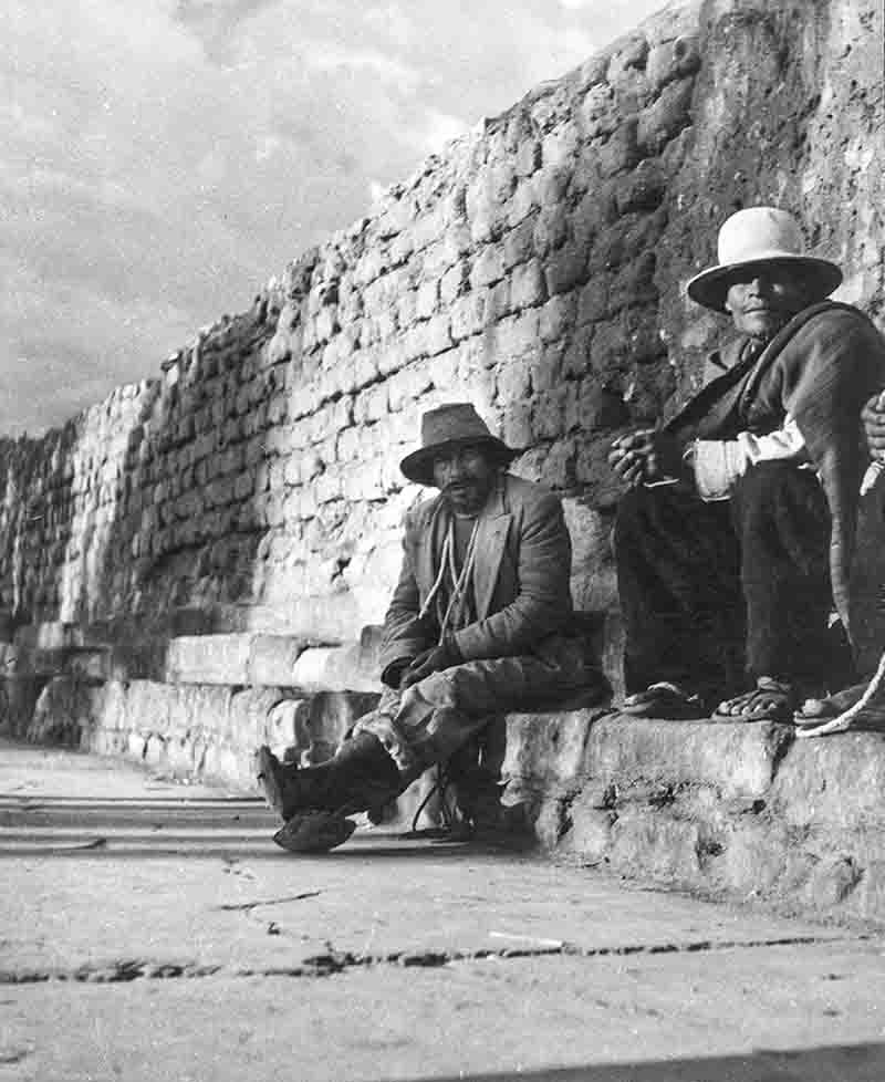 Peruvian Peasants sitting at sidewalk