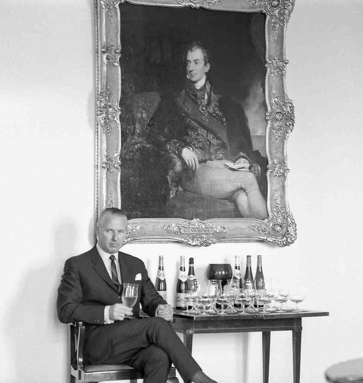 Prince Paul Alfons von Metternich-Winneburg sipping a glass of Metternich sparkling wine in front of an oil painting depicting his famous great-grandfather, Prince Clement von Metternich.
