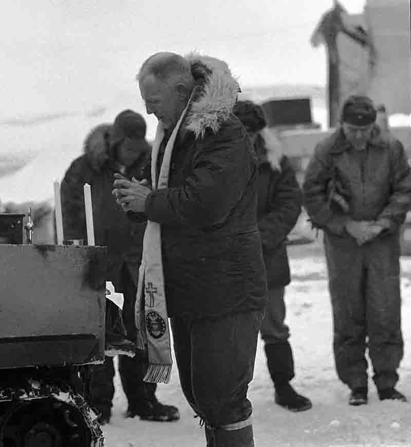 U.S. Army clergy prays and the men of the weather station humbly bow their heads on Drift Station Alpha in the Arctic Ocean.