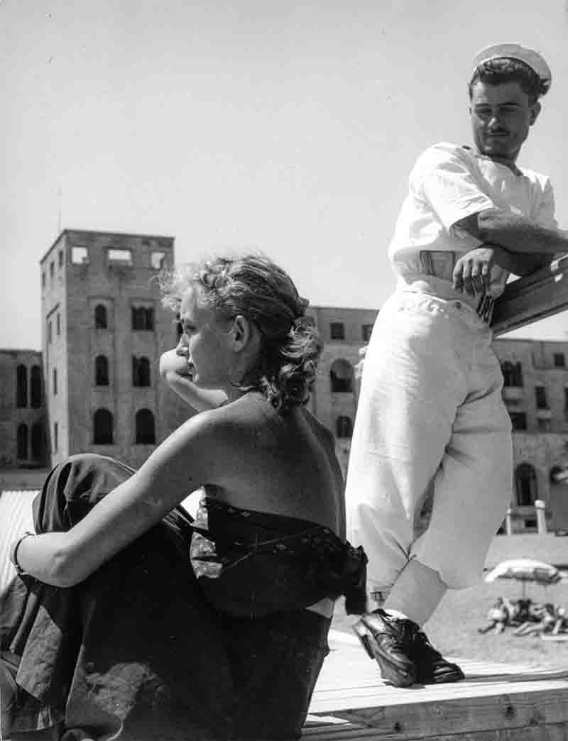 Sailor and blonde beauty in Madraki harbour in Rhodos Greece.