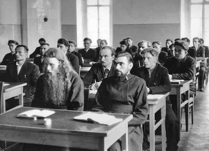 A monochrome image of a classroom filled with male Russian students engaged in learning activities.