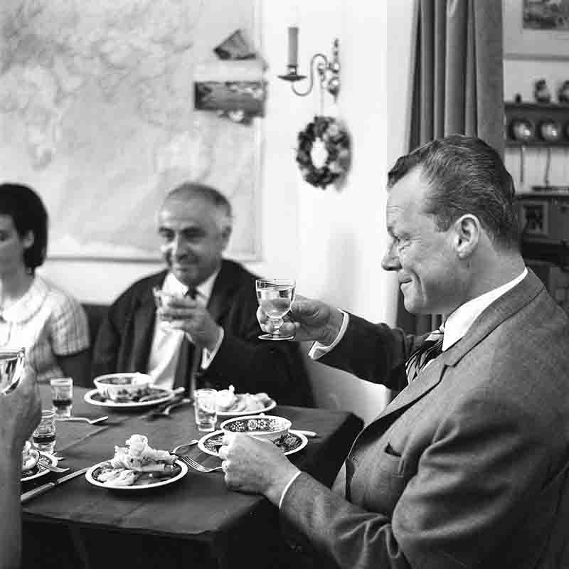 Willy Brandt, Chancellor of West Germany, toasting a family at the table